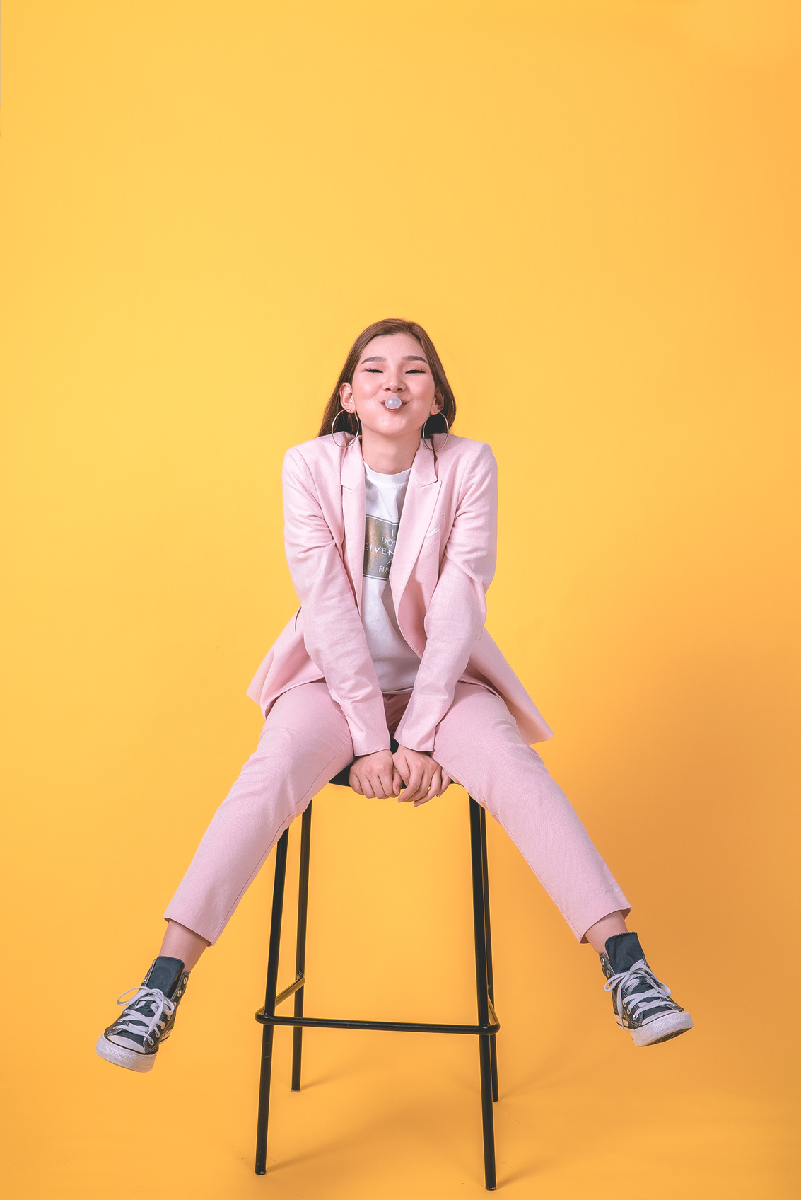 Woman in Pink Suit Sitting on Stool